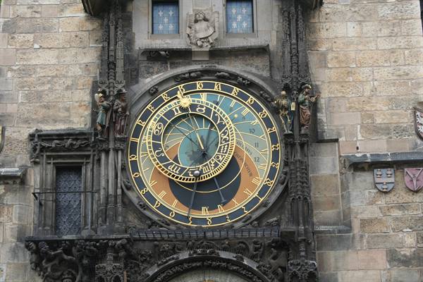 Medieval astronomical clock with blue and golden dial on Prague's stone facade