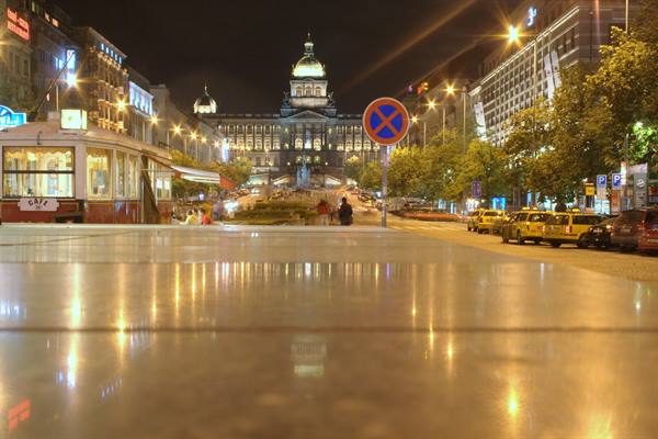 Wenceslas Square at night, the illuminated National Museum behind wet reflections