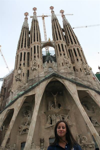 Tourist in front of the Sagrada Familia in Barcelona, towers and cranes