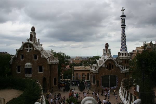 Visitors at Parc Güell entrance in Barcelona, Gaudí's stone pavilions and mosaic tower
