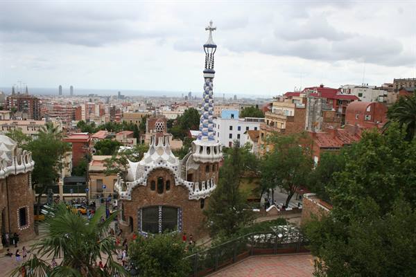 Gaudí pavilion with mosaic spire at Parc Güell, Barcelona under grey sky