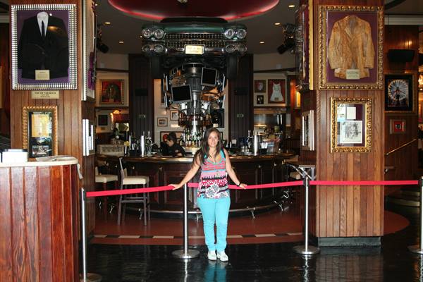 Smiling girl at the Hard Rock Cafe entrance, car suspended above the bar