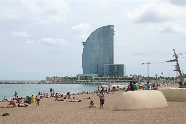 Barceloneta beach with the sail-shaped W Hotel and sunbathers on the sand
