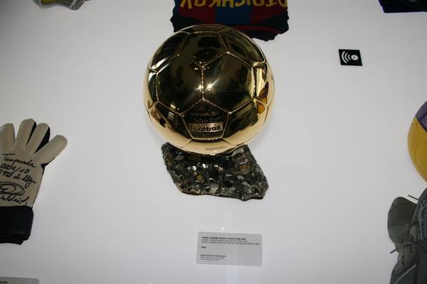 Golden Ball trophy on a stone base, displayed in a museum case