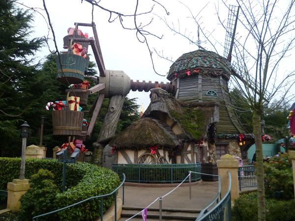 Wooden windmill with gift baskets, bare trees, gray sky