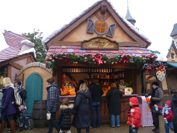 Visitors queue at the wooden Pains Marie stall decorated with Christmas garlands