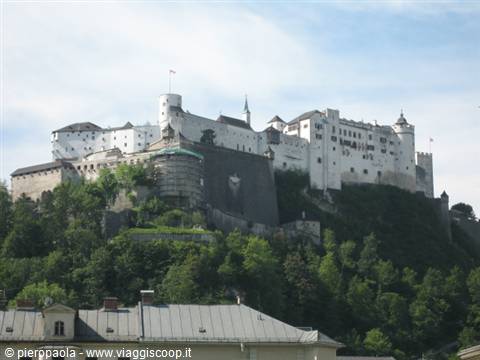 Hohensalzburg Fortress towers over Salzburg among green trees