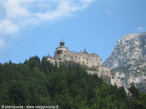 Hohenwerfen fortress towers above the forest beneath rocky alpine cliffs