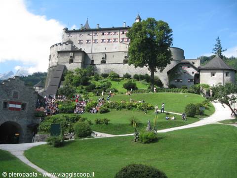 Hohenwerfen Castle with stone walls and towers above the green lawn