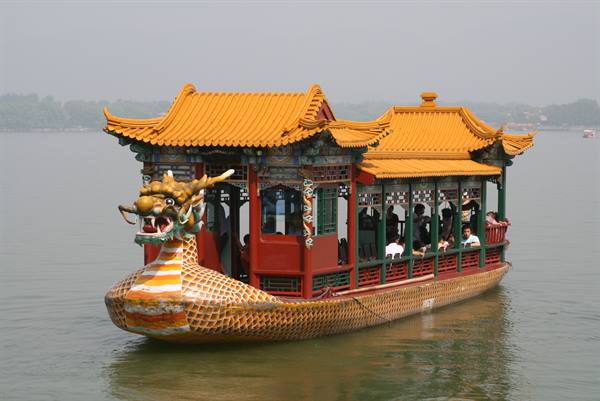 Dragon boat with golden head and yellow roofs carrying tourists on Kunming Lake
