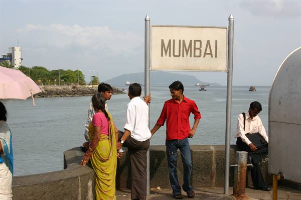 MUMBAI sign on the waterfront, people in sari standing by the sea