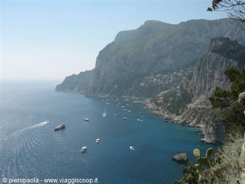 White boats on turquoise bay beneath Capri's limestone cliffs