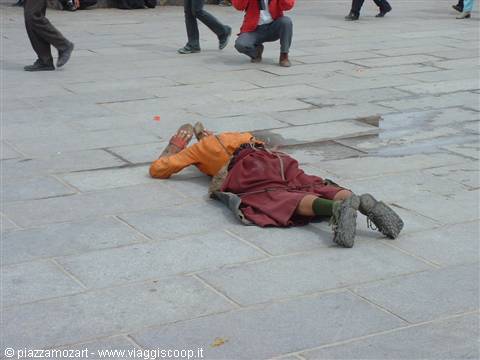 Tibetan pilgrim prostrating on the stone pavement before the Jokhang