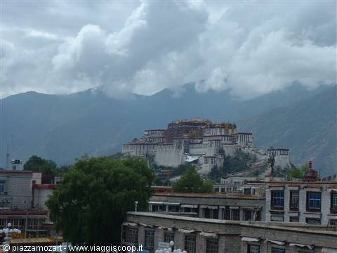 The Potala Palace in Lhasa under grey clouds, golden roofs, white buildings