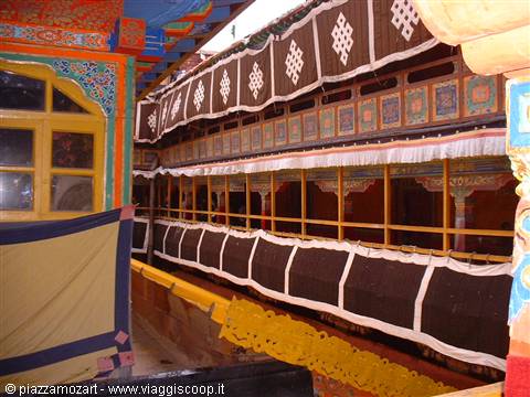 Tibetan monastery with painted facade, wooden balconies and dark draped cloth
