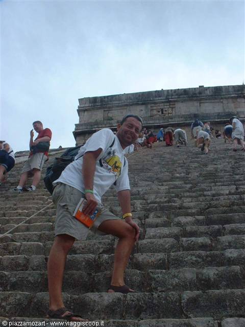 Tourist posing on the stone steps of the Chichén Itzá pyramid