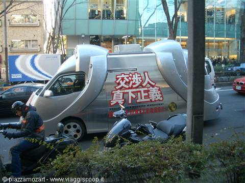 Silver van with Japanese writing in Tokyo city traffic