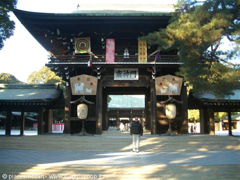 Visitor walks toward the large wooden gate of Meiji Shrine in Tokyo