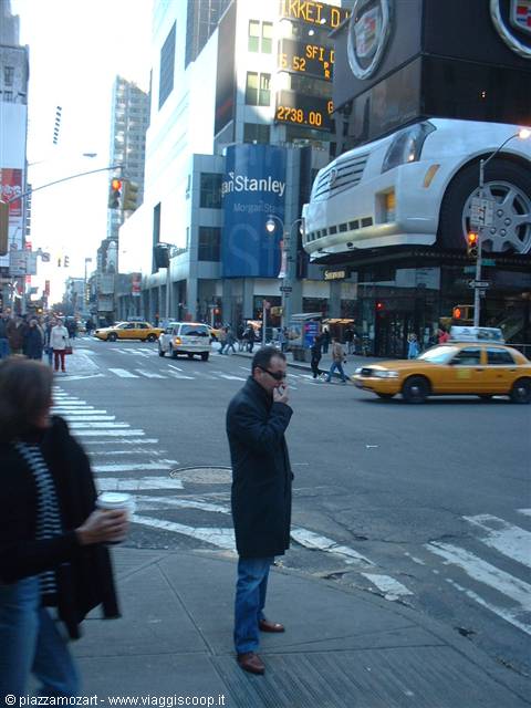 Man smoking at Times Square crossing, yellow taxis and glowing billboards