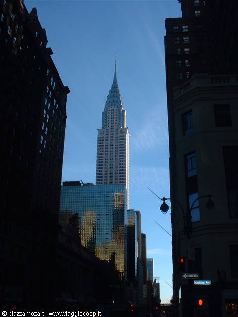 The Chrysler Building rises among skyscrapers under New York's blue sky