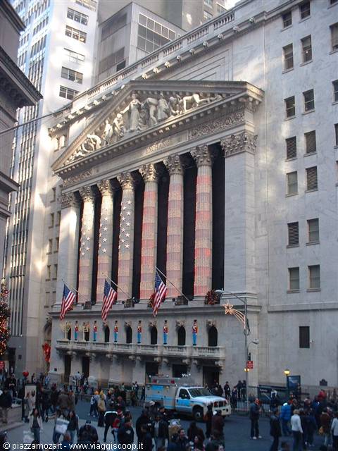 Marble facade of the New York Stock Exchange with columns, flags and crowd