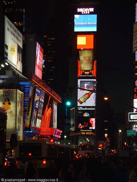 Times Square at night: glowing LED billboards, Broadway theatres, crowds and taxis