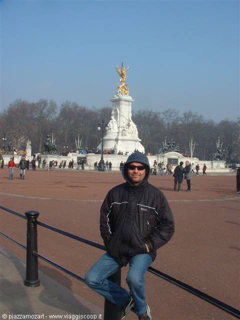 Tourist sitting on railing in front of Victoria Memorial, London