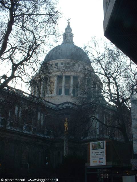 St Paul's Cathedral stone dome framed by bare branches under grey winter light