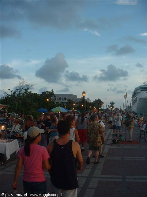 Crowd strolling Mallory Square pier in Key West beside a docked cruise ship