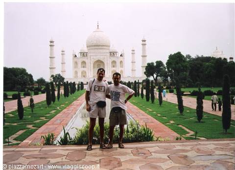 Two tourists posing in the Taj Mahal gardens in Agra