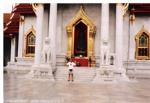 Tourist in front of Wat Benchamabophit marble temple, stone lions and golden Buddha