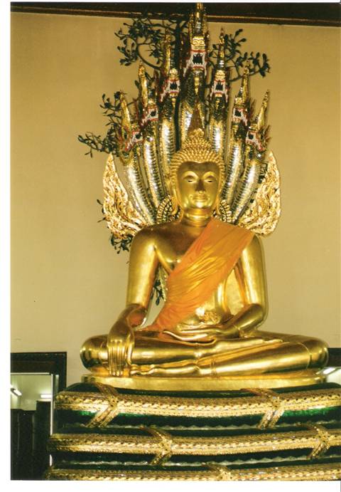 Golden seated Buddha sheltered by seven-headed naga, wearing orange sash