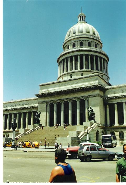 El Capitolio in Havana: stone dome, wide steps with tourists, cars under the sun