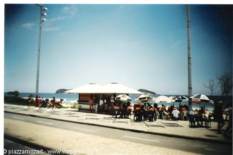 Kiosk with beach umbrellas at Copacabana, people sitting at tables