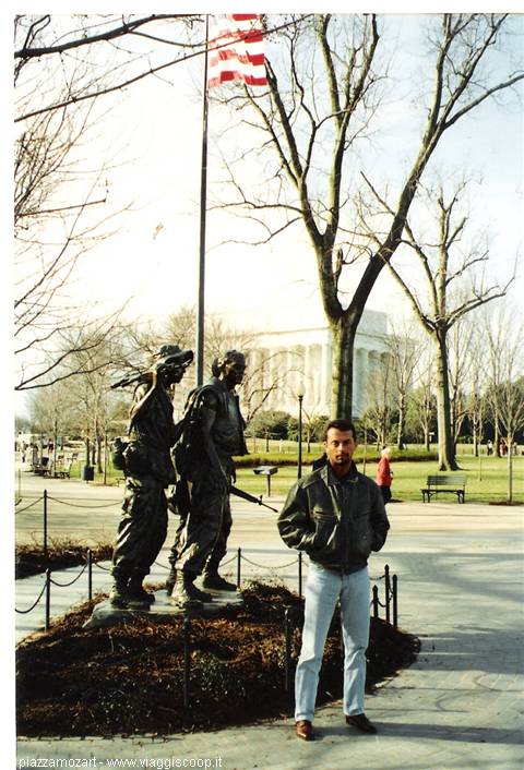 Bronze soldiers statue at the Vietnam Memorial, American flag, Lincoln Memorial behind