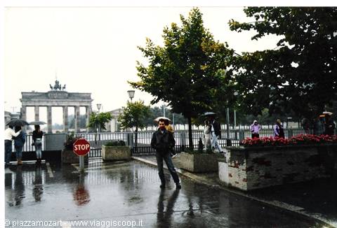 Rainy Berlin: tourist with umbrella in front of the Brandenburg Gate