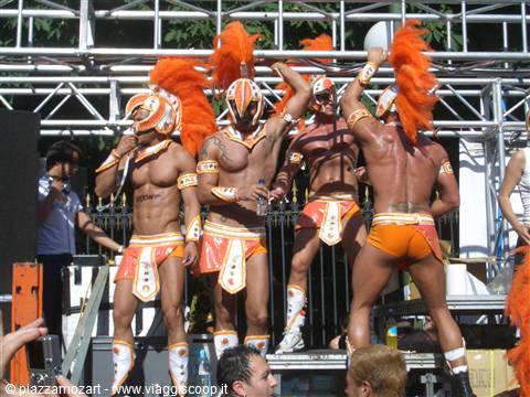 Dancers in orange feathered carnival costumes performing on stage