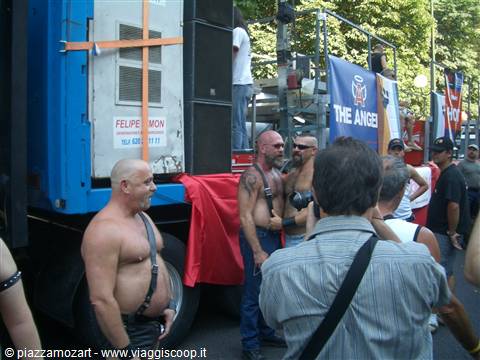 Men in leather harnesses beside a sound truck at Pride event