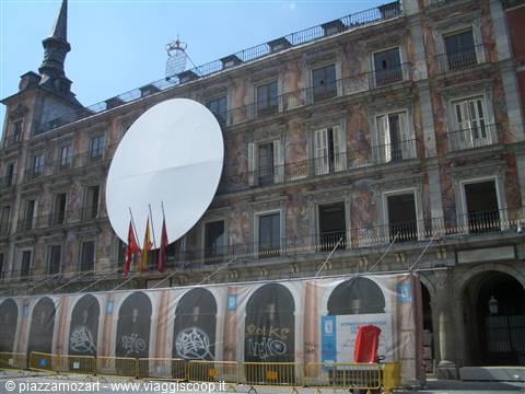 Plaza Mayor in Madrid: mural-painted facade, huge white disc, flags and advertising banners
