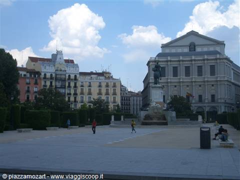 Equestrian statue in front of Madrid's Teatro Real, people strolling across the square