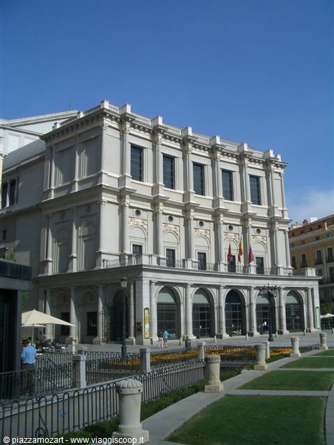 Neoclassical facade of the Teatro Royal opera house in Madrid with Spanish flags