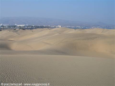 Maspalomas sand dunes with hotels and mountains in the background