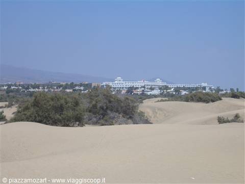 Sand dunes with shrubs and white hotel behind, Maspalomas