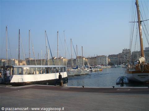 Boats moored at Marseille's old port, pale facades and ferry deck in foreground