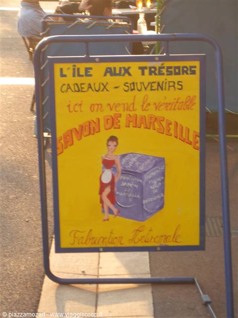 Yellow souvenir shop sign advertising Marseille soap on a street