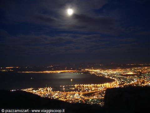 Cape Town at night: moonlit bay, golden harbor lights below Table Mountain