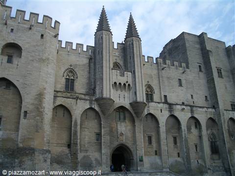 Stone facade of the Popes' Palace in Avignon with crenellated towers