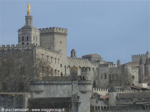 Papal Palace of Avignon in pale stone, golden Virgin tower, grey sky