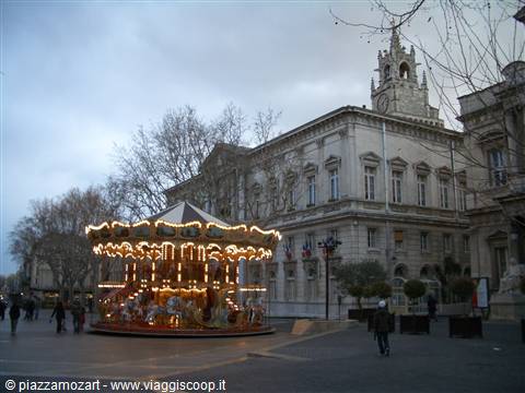 Illuminated carousel in front of Avignon town hall on Place de l'Horloge