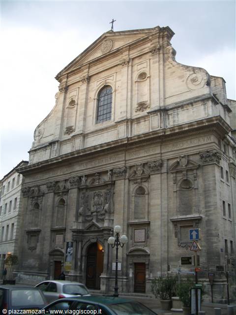 Baroque stone facade of Saint-Roch church, cars parked below